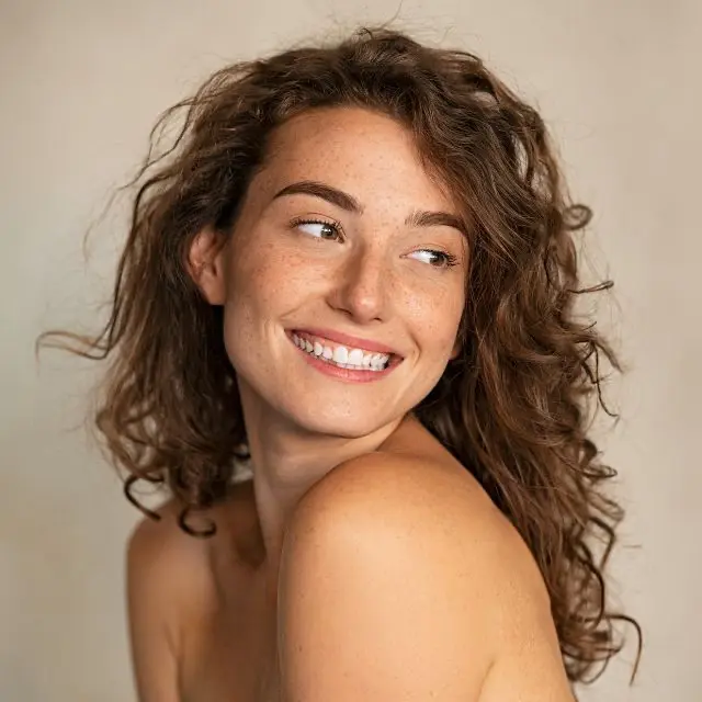 Mujer con melena rizada sonriene
